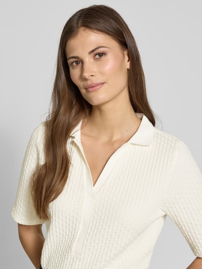 Frauenmodel trägt Regular Fit Poloshirt mit V-Ausschnitt von Betty Barclay aus Baumwoll-Mix mit Stretch-Anteil und Strukturmuster, Nahaufnahme Oberkörper.