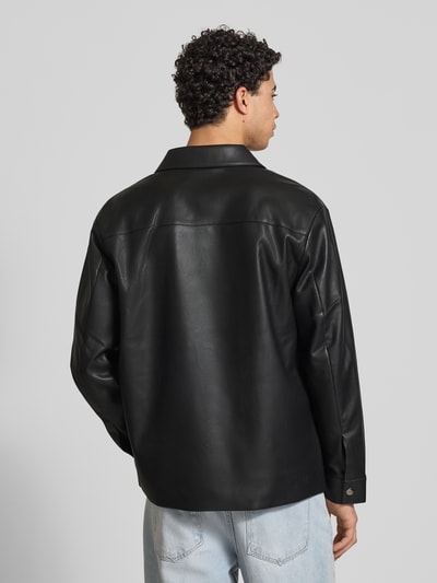 Mannelijk model draagt Regular Fit Hemdjacke in leerlook van Calvin Klein Jeans, zwart, platte kraag, borstzakken, knoopsluiting, sportmanchetten, ruglengte maat M 73 cm, schouderbreedte 50 cm, mouwlengte 65 cm, geheel te zien vanaf achteren.