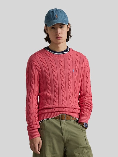 Męski model nosi Regular Fit Strickpullover aus reiner Baumwolle od Polo Ralph Lauren, czerwony, splot warkoczowy, logo, krój regular fit, widok całej sylwetki z przodu.