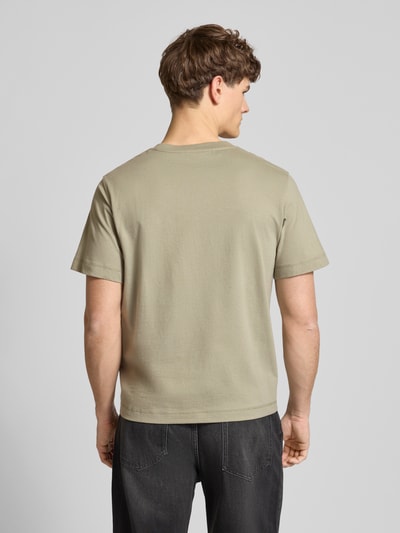 Männermodel trägt T-Shirt mit Rundhalsausschnitt Modell 'JORNORREBRO' von Jack & Jones, beige, reine Baumwolle, gerader Schnitt, Ganzkörperansicht Rückansicht.