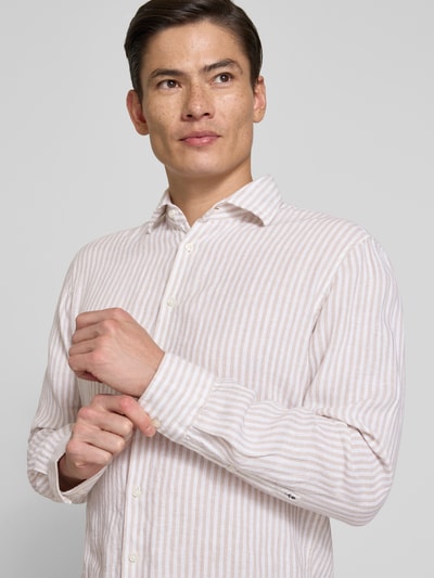 Männermodel trägt Regular Fit Business-Hemd aus Leinen mit Kentkragen von SEIDENSTICKER, beiges Streifenmuster, Knopfleiste, Nahaufnahme Oberkörper.