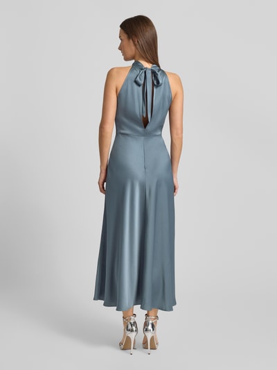 Frauenmodel trägt Maxikleid mit Neckholder Modell 'RHEO' von Samsøe Samsøe in glänzendem Blau, taillierter Schnitt, Rückansicht, Ganzkörperansicht