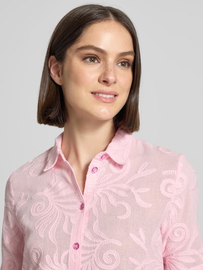 Kobiece model prezentuje Regular Fit Bluse mit Stitchings od Milano Italy, różowa bawełna z haftem, kołnierz koszulowy, guziki, krój regular fit, zbliżenie na górną część ciała.