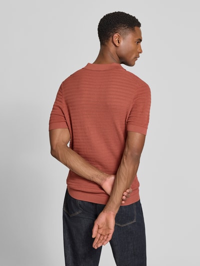 Männermodel trägt Slim Fit Strick-Poloshirt mit Strukturmuster Modell 'BRAIAN' von Drykorn in Rostrot, Rückenansicht, reine Baumwolle.