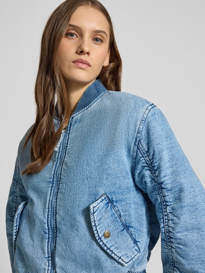 Vrouwenmodel draagt Bomberjacke mit Stehkragen und Reißverschluss Modell 'SCOUT' van Levi's®, regular fit, blauwe denim structuur, klepzakken, borstbreedte 48 cm, schouderbreedte 45 cm, mouwlengte 60 cm, ruglengte 53 cm, detailopname bovenlichaam