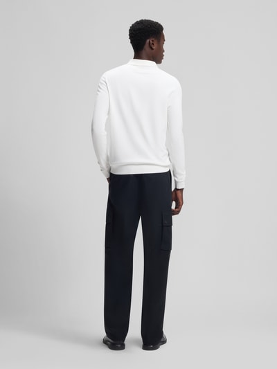 Männermodel trägt Slim Fit Strick-Poloshirt aus Viskose-Mix Modell 'SAN PIPPO-CV' von HUGO, unifarben in Weiß, Ganzkörperansicht Rückansicht.