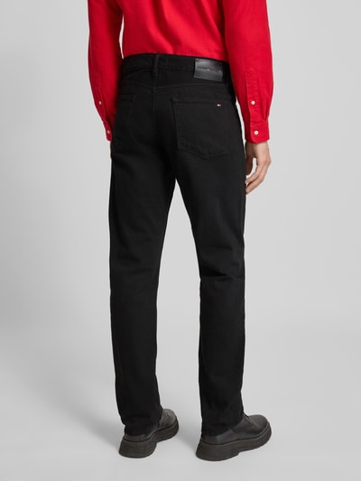 Männermodel trägt Straight Leg Jeans aus reiner Baumwolle von Tommy Hilfiger, Optik: Unifarben, 5-Pocket-Design, Ganzkörperansicht Rückansicht.