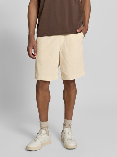 Mężczyzna nosi Regular Fit Sweatshorts aus Baumwoll-Mix Modell 'JACE' od SELECTED HOMME, kremowy sztruks, jednolity, krój regular fit, boczne kieszenie, szlufki na pasek, sznurek w pasie, bawełniany miks, całkowity widok z przodu.