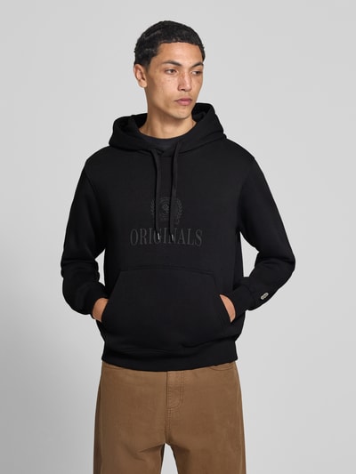 Männermodel trägt Hoodie aus Baumwoll-Mix Modell 'FREDERIKS' von JACK & JONES, schwarze Farbe, Kängurutasche, Nahaufnahme Oberkörper.