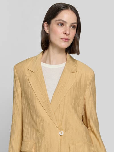 Frauenmodel trägt Straight Fit Blazer aus Viskose-Mix mit Strukturmuster von Jake*s Collection, sandfarben, Reverskragen, Nahaufnahme Oberkörper.