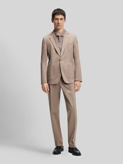 Männermodel draagt Slim Fit Sakko aus katoenmix model 'HANFRED262X' van HUGO in effen kleuren, reverskraag, 2-knoopsluiting, borstzak, opgestikte zijzakken, lange mouw met kissing buttons, rompzoom met zijsplitten, materiaalverwerking: geweven katoenmix. Ganzkörperansicht van voren.