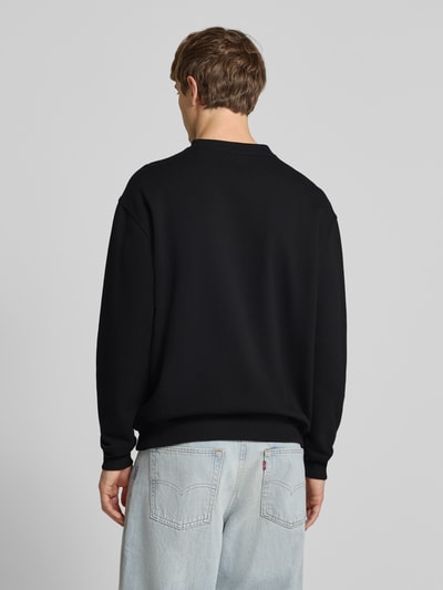 Männermodel trägt Sweatshirt mit Label-Print Modell 'TORREY' von DICKIES, Schwarz, Baumwoll-Mix, Lockerer-Schnitt, Ganzkörperansicht Rückansicht.
