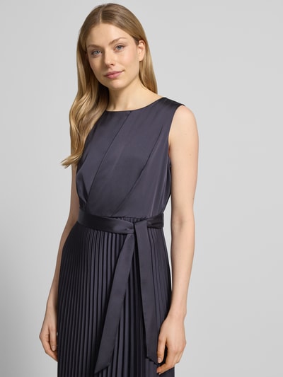 Frauenmodel trägt Midikleid mit Plisseefalten und Bindegürtel von Comma, Material-Mix mit Stretch-Anteil, A-Linie, Nahaufnahme Oberkörper.