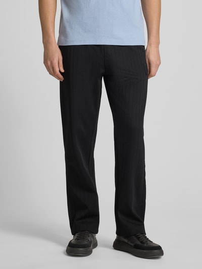 Männermodel trägt Regular Fit Sweatpants aus Baumwoll-Mix Modell 'DAVROPANT' von HUGO, Optik: unifarben, Muster: gestreift, Label-Patch und Label-Stitching, Tunnelzug-Verschluss, elastischer Bundabschluss, seitliche Eingrifftaschen, Sweat-Material, Beinabschluss mit Seitenschlitz und Reißverschluss, Ganzkörperansicht von vorne.