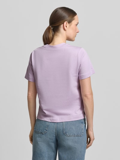Kobiece modelka nosi T-Shirt mit Motiv-Print Modell 'FIORE' od Stefanel w kolorze jasnofioletowym, prosta bawełna, okrągły dekolt, długość pleców w rozmiarze S: 55 cm, widok całej sylwetki z tyłu.