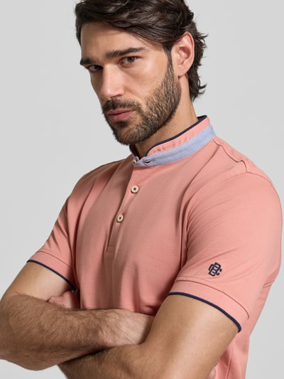 Männermodel trägt Regular Fit Poloshirt aus reiner Baumwolle mit Stehkragen von Christian Berg Men in Rosa, Nahaufnahme Oberkörper.