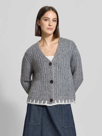 Kobiece modelka nosi Regular Fit Pullover mit Woll-Anteil Modell 'Kustra' od JOOP!, szary sweter z dodatkiem wełny i dużymi guzikami, widoczny detal biały przy dole, sweter damski od JOOP!, widok całej sylwetki z przodu.