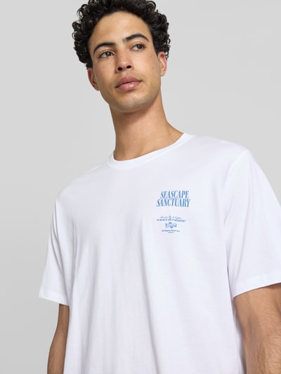 Männermodel trägt Relaxed Fit T-Shirt mit Statement-Print Modell 'Photo' von Jack & Jones aus reiner Baumwolle in Weiß, Nahaufnahme Oberkörper.