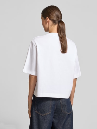 Frauenmodel trägt Relaxed Fit T-Shirt aus reiner Baumwolle von Rich & Royal, weiß, strukturierte Oberfläche, Ganzkörperansicht Rückansicht.