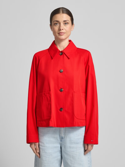 Kobiece model prezentuje Relaxed Fit Trenchcoat aus reiner Baumwolle od Tommy Hilfiger, kolor czerwony, gładki twill, wodoodporny, długość cropped, logo, widok całej sylwetki z przodu.