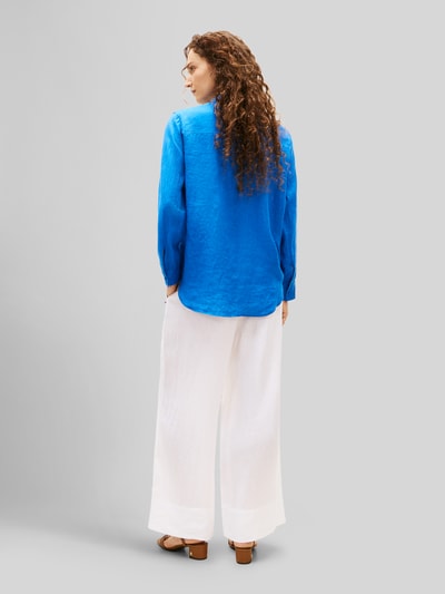 Frauenmodel trägt Relaxed Fit Langarmbluse aus reinem Leinen von Tommy Hilfiger in kräftigem Blau, Optik: Unifarben, Passform: Relaxed-Fit, Kragenform: Hemdkragen, Applikation: Logo-Stitching, Verschluss: Knopfleiste, Ärmelform: Langarm, Ärmelabschluss: Manschette, Rumpfabschluss: Abgerundet, Materialverarbeitung: Flammgarn, Material: Leinen, Ganzkörperansicht Rückansicht.