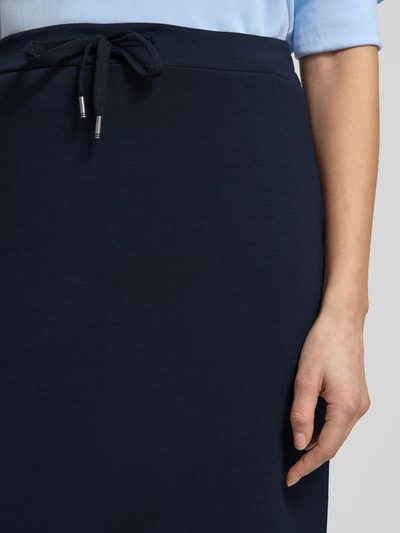 Kobiece modelka nosi Midirock mit elastischem Bund und Schnürung od Soyaconcept, granatowy materiał z domieszką modalu, detaliczny widok talii, szerokość w rozmiarze S: 40 cm, długość całkowita w rozmiarze S: 85 cm, prosty krój