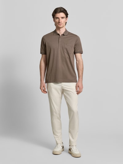 Męski model nosi Regular Fit Koszulkę polo z brustaszą od RAGMAN z bawełny, kołnierzyk polo, wyhaftowane logo, kolor brązowy, Ganzkörperansicht von vorne.