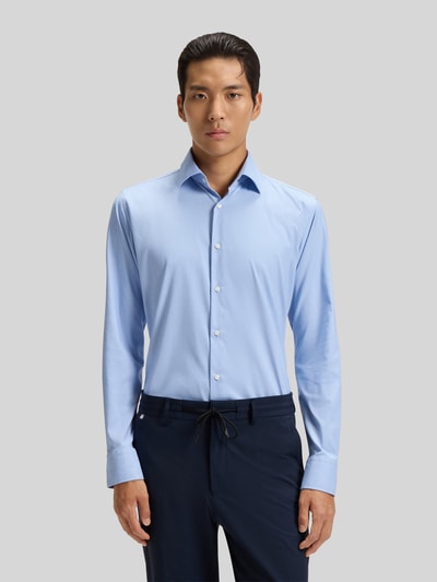 Männermodel trägt Slim Fit Businesshemd aus Stretch-Twill Modell 'P-HANK-KENT-C1-222' von BOSS in Hellblau, Ganzkörperansicht von vorne.