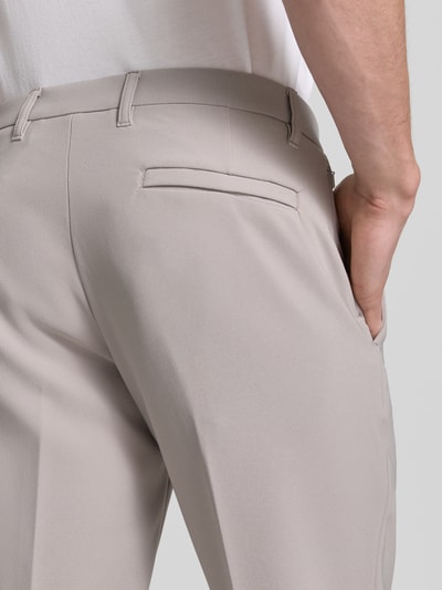 Männermodel trägt Straight Fit Stoffhose mit Bügelfalten von MCNEAL in Beige, elastischer Stoff, Gesäßtasche, Nahaufnahme Rückansicht.