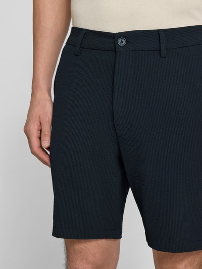 Männermodel trägt Regular Fit Bermudas mit Viskose-Anteil Modell 'KANE1' von BOSS, Melange-Optik, gestreift, Nahaufnahme Oberschenkel.