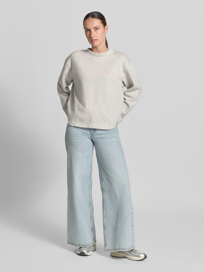 Frauenmodel trägt Relaxed Fit Sweatshirt aus Baumwoll-Mix von Emily Van den Bergh in Hellgrau mit Statement-Stitching und Rundhalsausschnitt, Ganzkörperansicht von vorne.