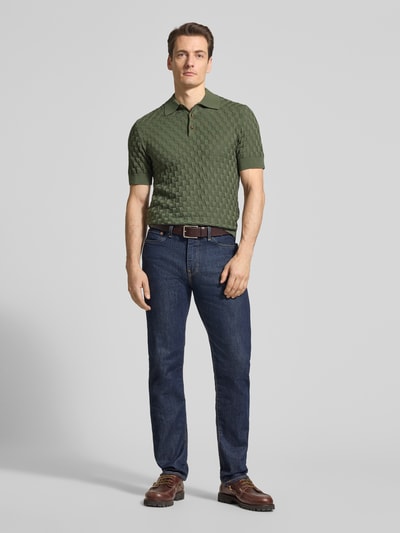 Männermodel trägt Slim Fit Poloshirt aus reiner Baumwolle Modell 'Heritage' von Matinique in Grün, Polokragen, gerippte Abschlüsse, Ganzkörperansicht von vorne.