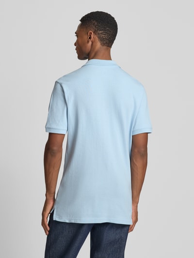 Männermodel trägt Slim Fit Poloshirt mit Label-Stitching von GAP in Hellblau, Baumwoll-Elasthan-Mix, Rückenansicht, Ganzkörperansicht.