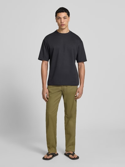 Männermodel trägt Relaxed Fit Hose aus Baumwoll-Leinen-Mix Modell 'KANE' von Jack & Jones in Beige mit elastischem Bund, Gesäßtaschen, Ganzkörperansicht von vorne. Herren Hose, Bundweite 42 cm, Innenbeinlänge 82 cm, Schnürung, Produktkontext inkludiert.