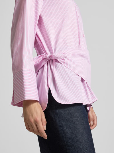 Frauenmodel trägt Regular Fit Hemdbluse aus Baumwoll-Mix Modell 'Dita' von Neo Noir, rosa-weiß gestreift, elastisch, Nahaufnahme Oberkörper.