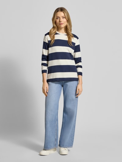 Modelka nosi bluzę Sweatshirt mit geripptem Rundhalsausschnitt Modell 'BARNI' od Soyaconcept, materiał z dodatkiem modalu, krój regular fit, granatowo-białe szerokie pasy, gładka tekstura, widok całej sylwetki z przodu.