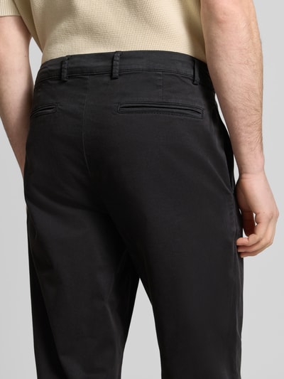Männermodel trägt heren chino met steekzakken model 'PEPE' van Casual Friday in zwart, regular fit, detailaufnahme achterzijde. Context: heren chino van Casual Friday, regular fit, knoop- en ritssluiting, model 'PEPE', steekzakken, achterzakken, bandwijdte bij maat 32/32: 44 cm, binnenbeenlengte bij maat 32/32: 72 cm.