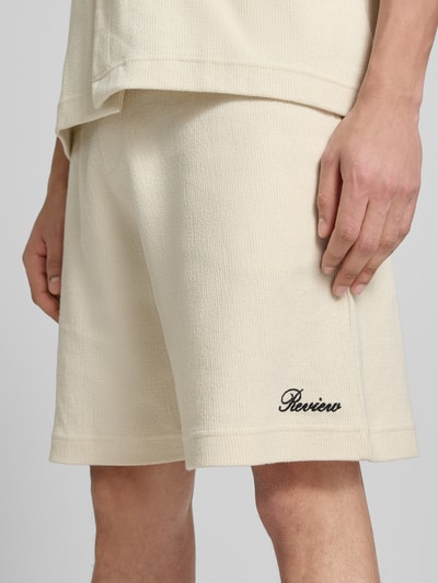 Männermodel trägt Shorts mit Label-Stitching von REVIEW aus Baumwoll-Mix, Regular-Fit, Strukturmuster, Nahaufnahme Oberschenkel.