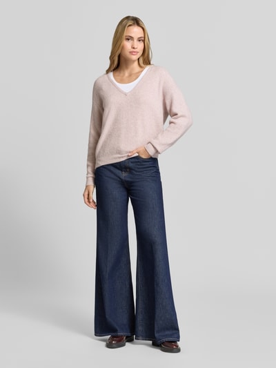 Kobiece modelka ma na sobie sweter z dzianiny z mieszanką lnu, efekt prążkowania, dekolt w serek, Model 'DAMSVILLE' od American Vintage, luźny krój, wykończenia elastyczne, długość tyłu w rozmiarze XS/S: 61 cm, długość rękawa w rozmiarze XS/S: 54 cm, widok całej sylwetki z przodu.