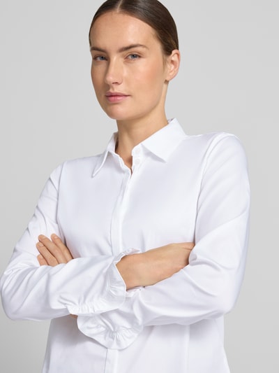 Kobiece modelka nosi bluzkę koszulową z mieszanki bawełny Model 'Mattie' od MOS MOSH, krój slim fit, z kołnierzykiem koszulowym, falbany na zakończeniach rękawów, długi rękaw, listwa guzikowa na całej długości, zaokrąglony dół, długość tyłu 70 cm, długość rękawów 62 cm, widok z przodu, zbliżenie górnej części ciała.