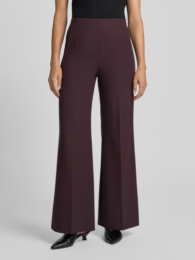 Frauenmodel trägt Flared Fit Hose mit Viskose-Anteil von windsor, dunkelbraun, elastischer Bund, Bügelfalten, Ganzkörperansicht von vorne.