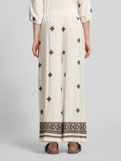 Frauenmodel trägt Hose aus Viskose-Leinen-Mix mit Stitchings von Christian Berg Woman Selection in Creme mit braunen Details, Ganzkörperansicht Rückansicht.