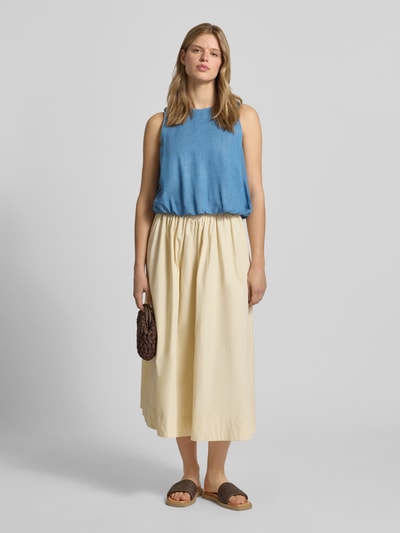 Frauenmodel trägt Ballon Fit Blusentop aus reinem Lyocell Modell 'CHARIS' von Only in Denim-Optik mit Rundhalsausschnitt und Raffungen, Ganzkörperansicht von vorne.