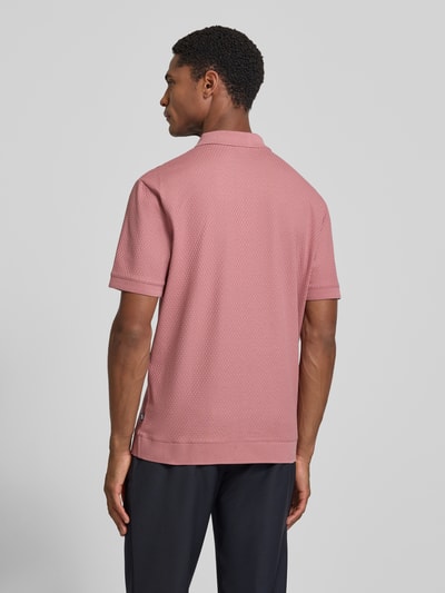 Männermodel trägt Regular Fit Poloshirt mit Strukturmuster Modell 'Tibaris' von JOOP! COLLECTION in Rosa, Label-Stitching, Polokragen, Reißverschluss, Rückenlänge bei Größe M 70 cm, Ganzkörperansicht Rückansicht.