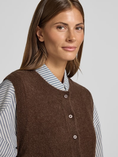 Frauenmodel trägt Strickweste mit Rundhalsausschnitt Modell 'Bondie Hope' von MSCH Copenhagen, braun, Knopfleiste, Nahaufnahme Oberkörper.