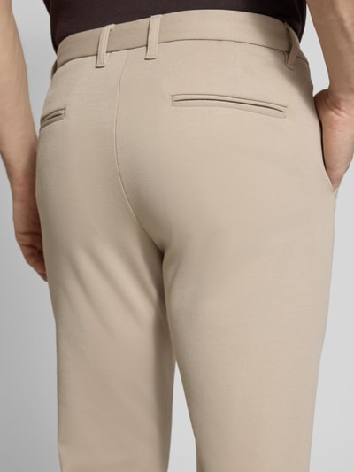 Männermodel trägt Cropped Hose mit Eingrifftaschen von Lindbergh in Beige, fein strukturiert, Material-Mix mit Viskose-Anteil, Detailaufnahme Rückansicht.