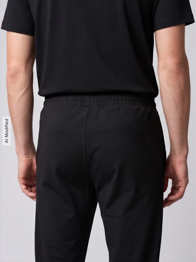 Mężczyzna nosi czarne spodnie Slim Fit Trainingshose mit Logo-Patch von Lacoste Sport, tekstura gładka, zdjęcie całej sylwetki z tyłu, KI-modifiziertes Bild