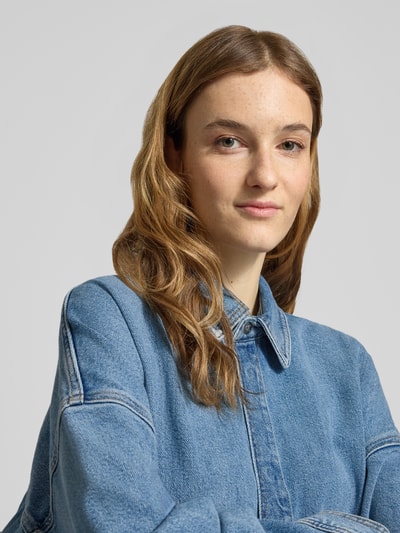 Vrouwenmodel draagt 'Jeansbluse mit Hemdblusenkragen' van Calvin Klein Jeans in denim-look, pure katoen, losse fit, close-up bovenlichaam.