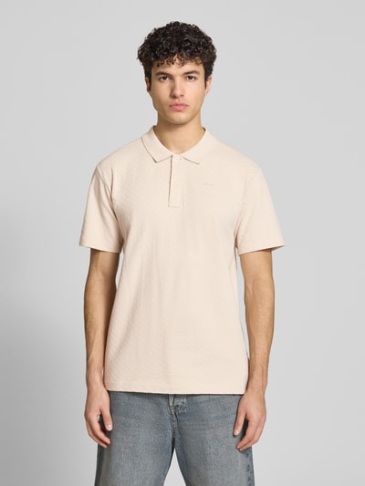 Männermodel trägt Regular Fit Poloshirt mit Logo von G-Star Raw aus Reine Baumwolle, dezente Farbe, Knopfleiste, Ganzkörperansicht von vorne. Rückenlänge bei Größe M: 74 cm.