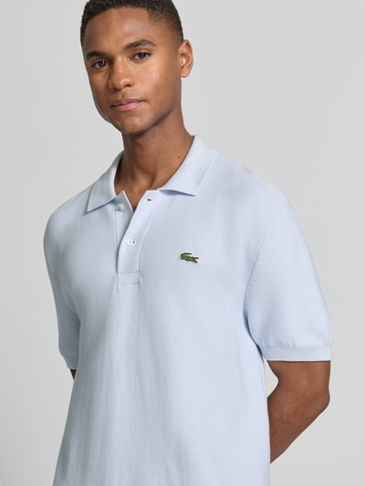Mannelijk model draagt Regular Fit poloshirt uit puur katoen van Lacoste in effen kleuren, logostitching, polokraag, korte mouw, rompzoom, materiaalverwerking: dwarsgebreid. Nahaufnahme bovenlichaam.